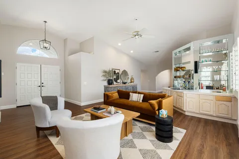 a living room with furniture a chandelier and a wooden floor