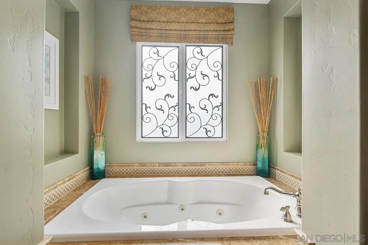 6941 Sitio Cordero Carlsbad, CA 92009 - Photo 18 of 44 a white bath tub sitting in a bathroom next to a window