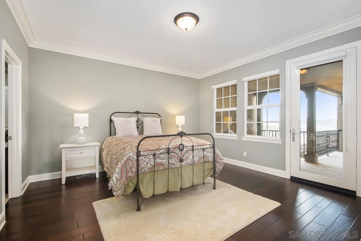 6941 Sitio Cordero Carlsbad, CA 92009 - Photo 22 of 44 a bedroom with a bed and wooden floor