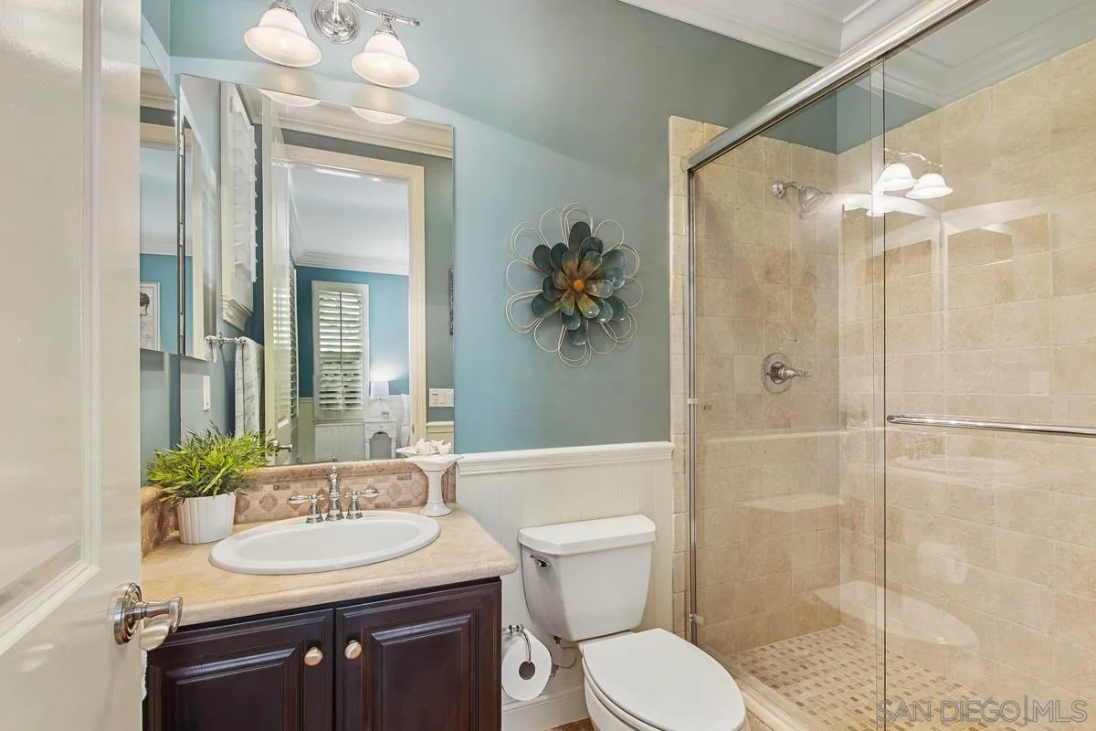 6941 Sitio Cordero Carlsbad, CA 92009 - Photo 25 of 44 a bathroom with a sink toilet a mirror and shower