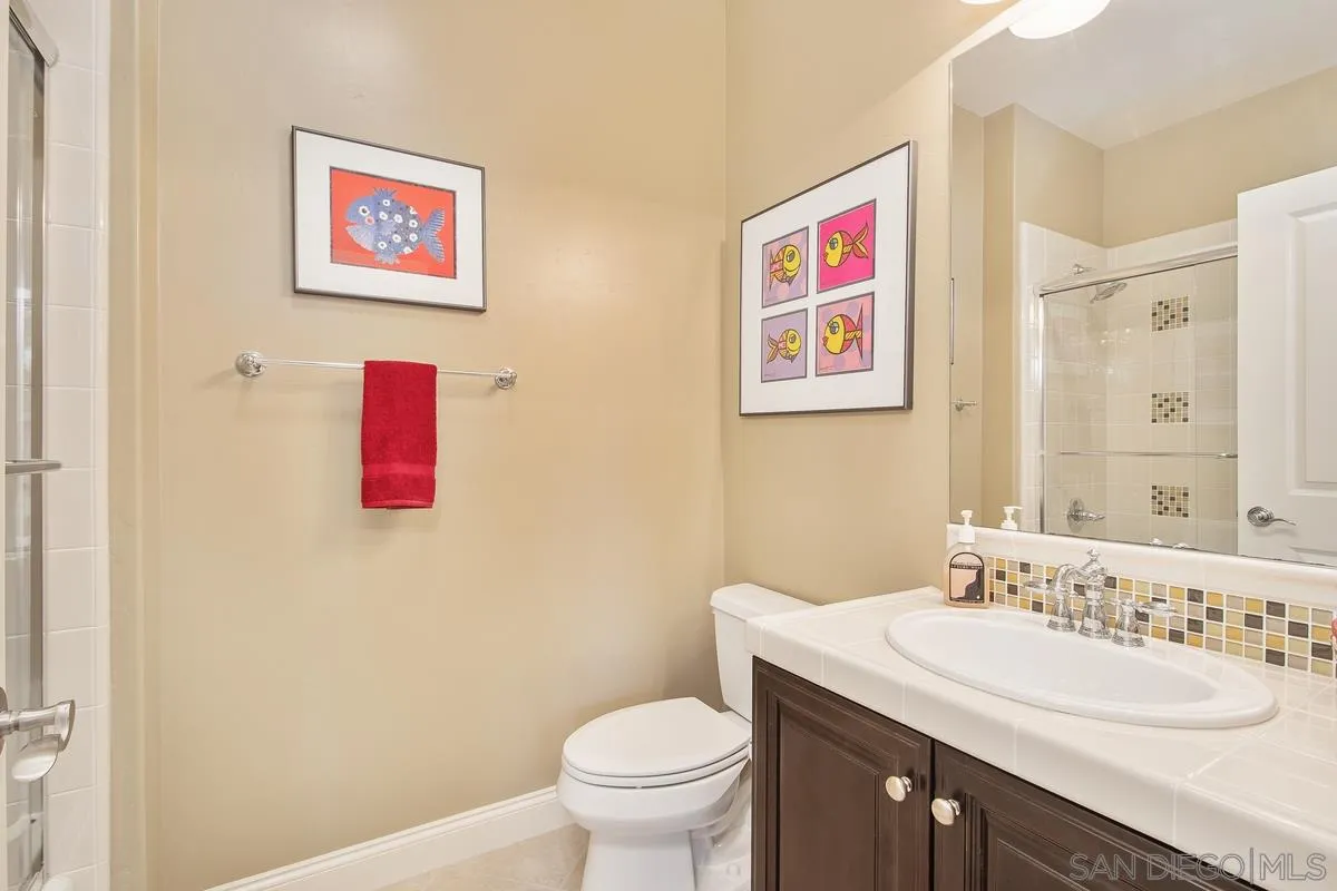 6941 Sitio Cordero Carlsbad, CA 92009 - Photo 28 of 44 a bathroom with a toilet sink and mirror