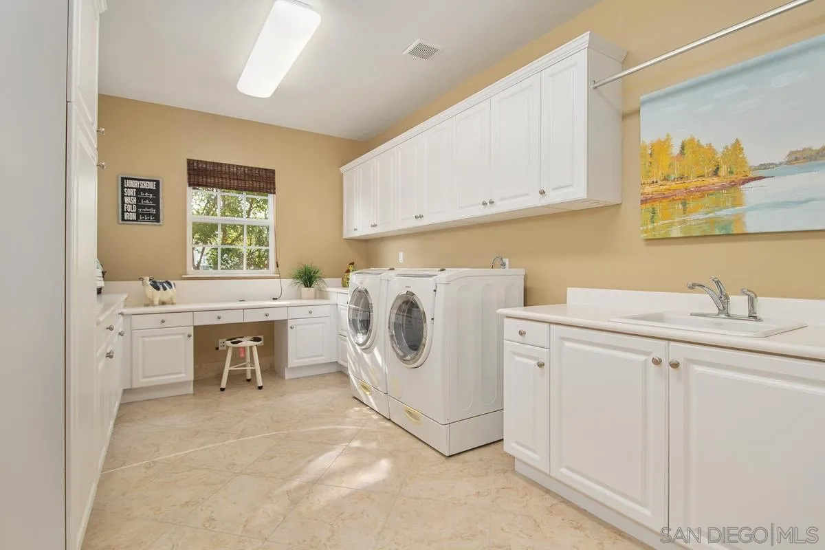 6941 Sitio Cordero Carlsbad, CA 92009 - Photo 29 of 44 a utility room with cabinets washer and dryer