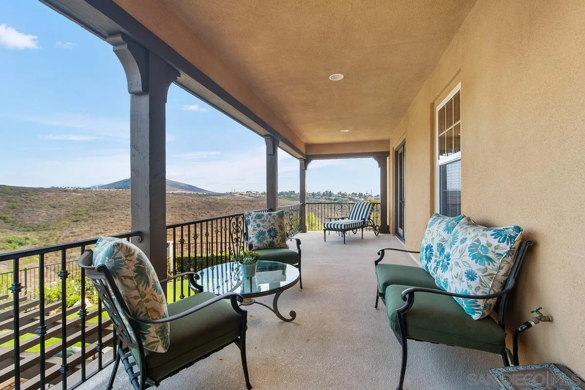 6941 Sitio Cordero Carlsbad, CA 92009 - Photo 36 of 44 a balcony with furniture and a floor to ceiling window