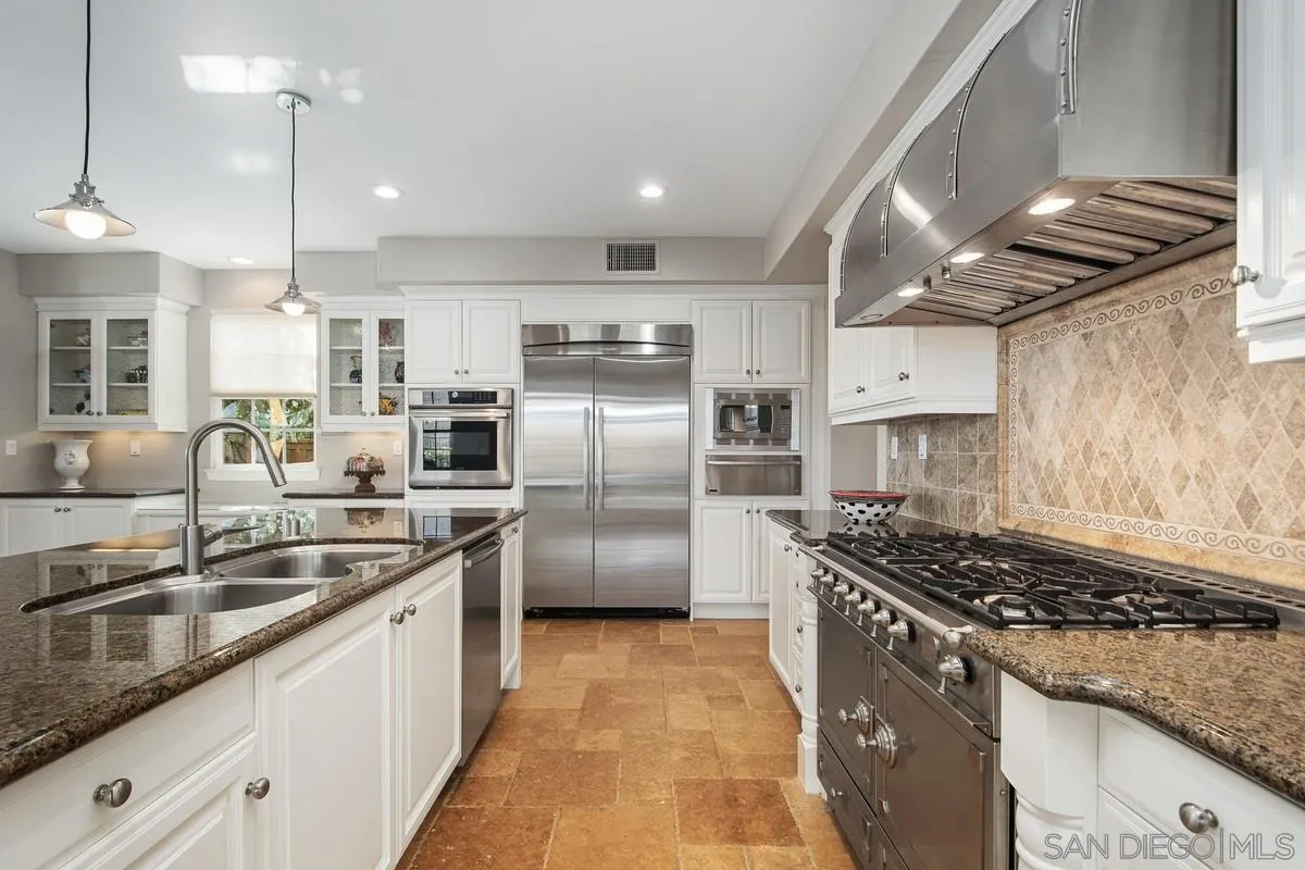 6941 Sitio Cordero Carlsbad, CA 92009 - Photo 6 of 44 a kitchen with stainless steel appliances granite countertop a sink stove and refrigerator