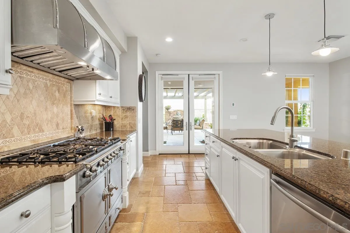 6941 Sitio Cordero Carlsbad, CA 92009 - Photo 8 of 44 a kitchen with stainless steel appliances granite countertop a sink stove and cabinets