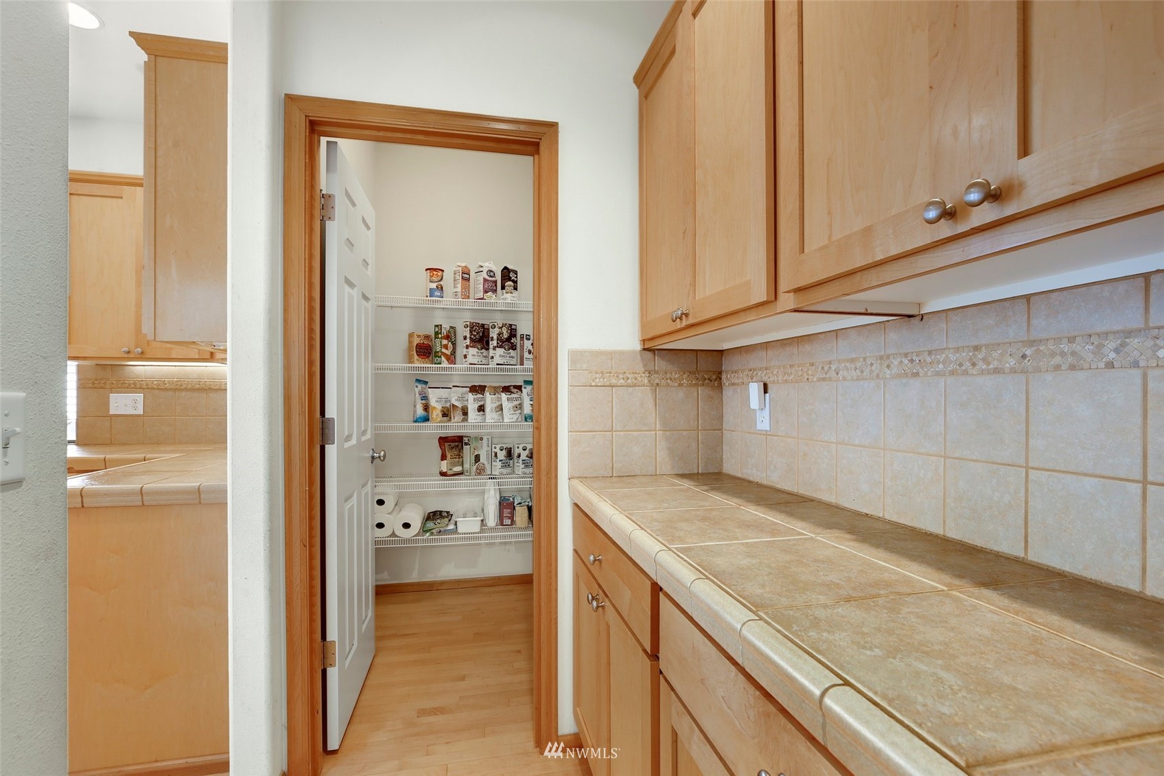4127 Northeast 5th Court Renton, WA 98059 - Photo 20 of 36 a kitchen with granite countertop white cabinets and a wooden floor