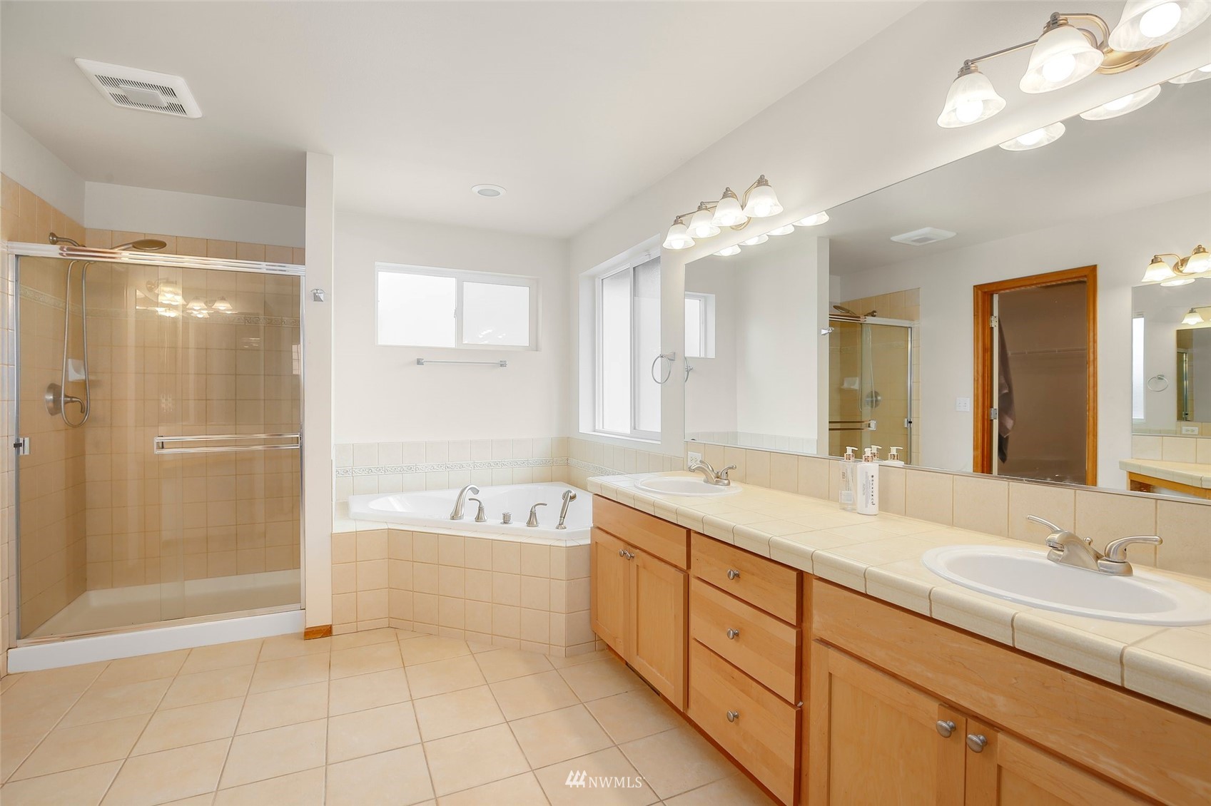 4127 Northeast 5th Court Renton, WA 98059 - Photo 26 of 36 a spacious bathroom with a tub sink shower and mirror