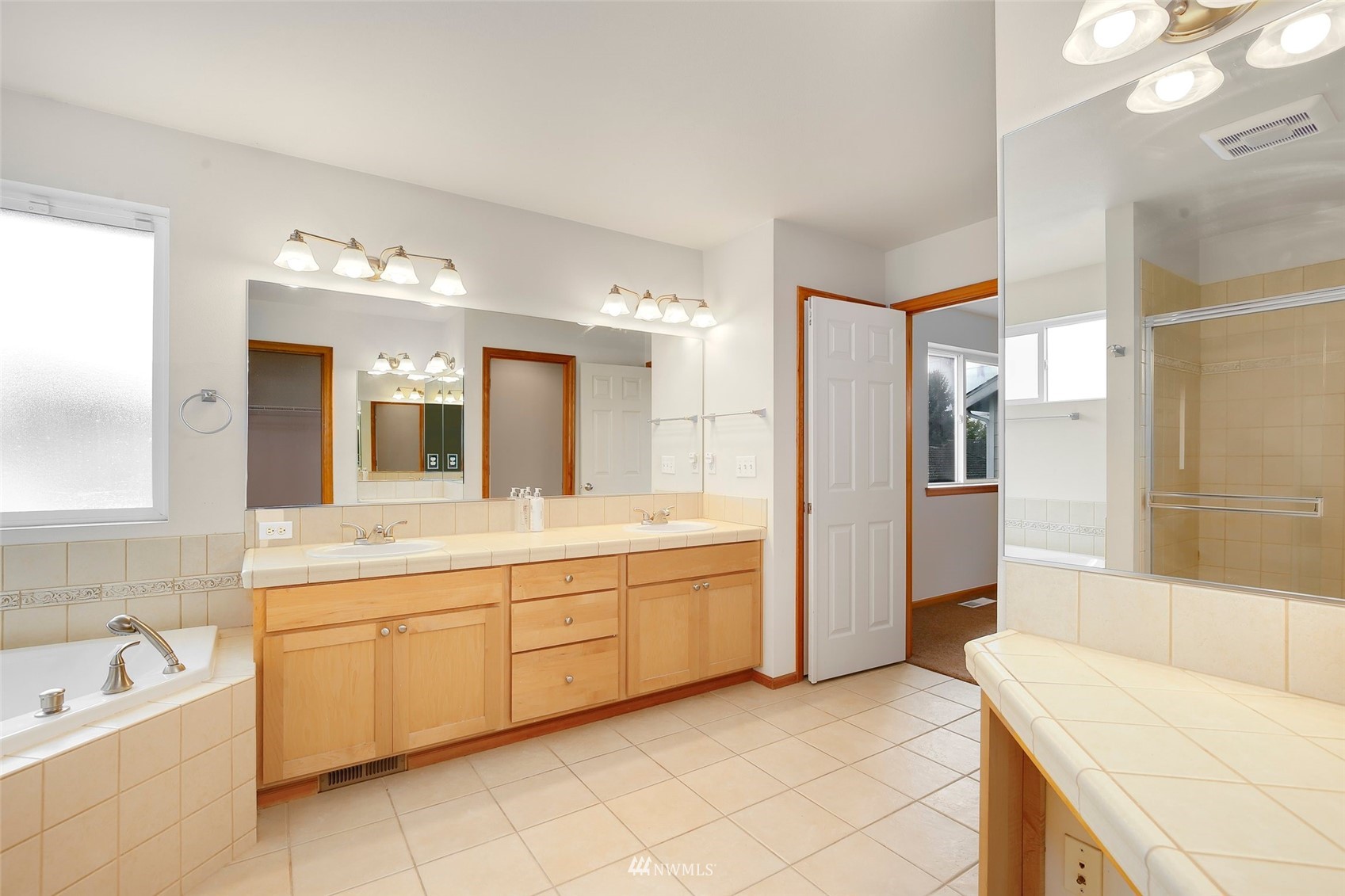 4127 Northeast 5th Court Renton, WA 98059 - Photo 27 of 36 a spacious bathroom with a tub sink and mirror