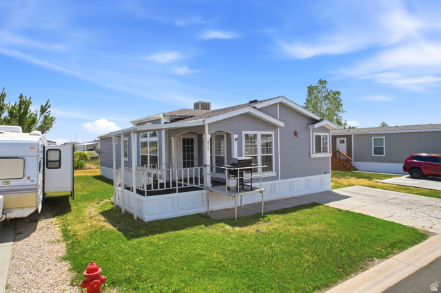 2491 Highway 89, Unit 614 Pleasant View, UT 84404 - Photo 4 of 27 Exterior featuring gray siding, white trim, a covered front porch with white railing, and multiple windows