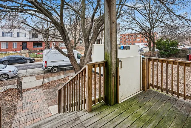 a view of house with wooden deck and trees