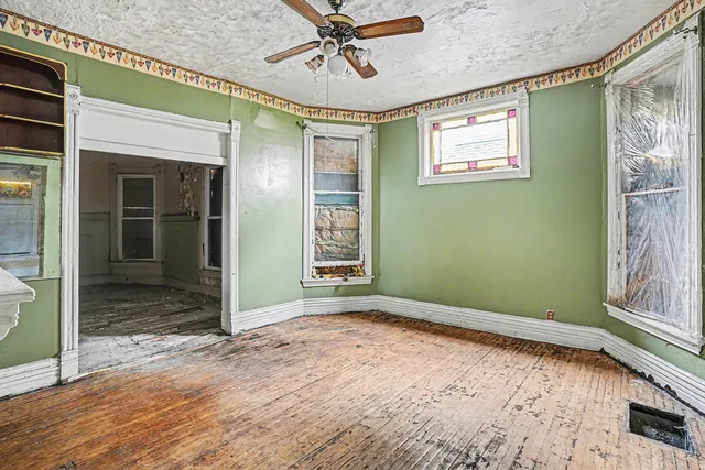 a view of empty room with window and wooden floor