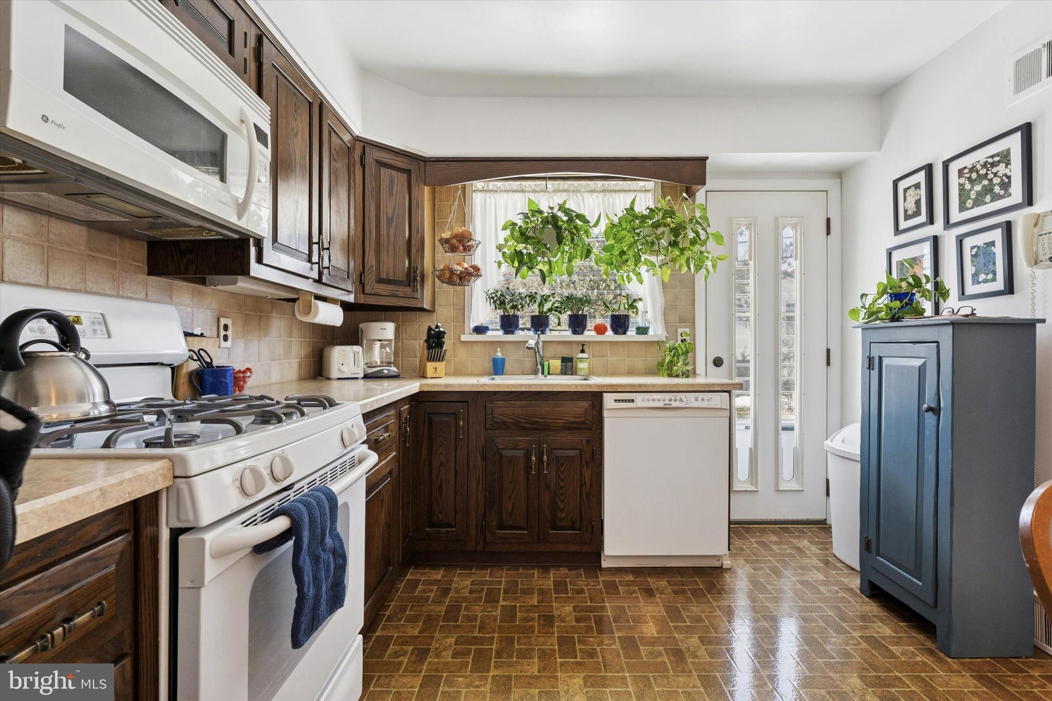 9204 Burbank Road Philadelphia, PA 19115 - Photo 14 of 43 a kitchen with a stove a sink and a refrigerator