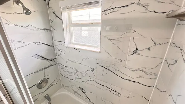 a bathroom with a bathtub and shower