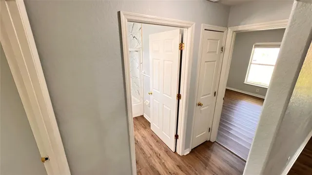 a view of a hallway with wooden floor and staircase