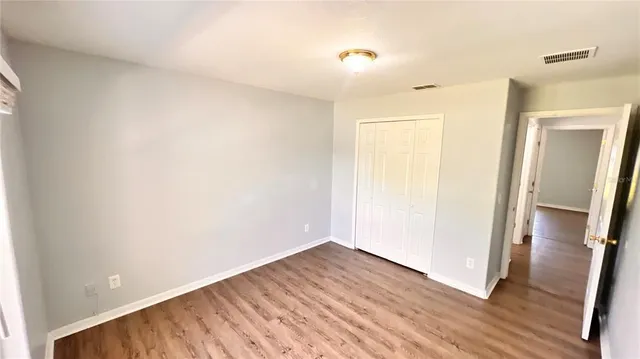an empty room with wooden floor and a window