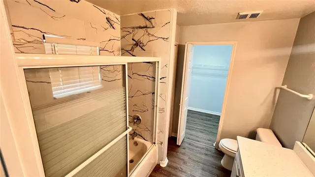 a bathroom with a sink a toilet a mirror and shower