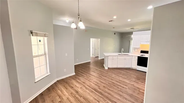 a view of a kitchen with a sink dishwasher and wooden floor