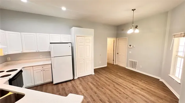 a kitchen with white cabinets and white appliances