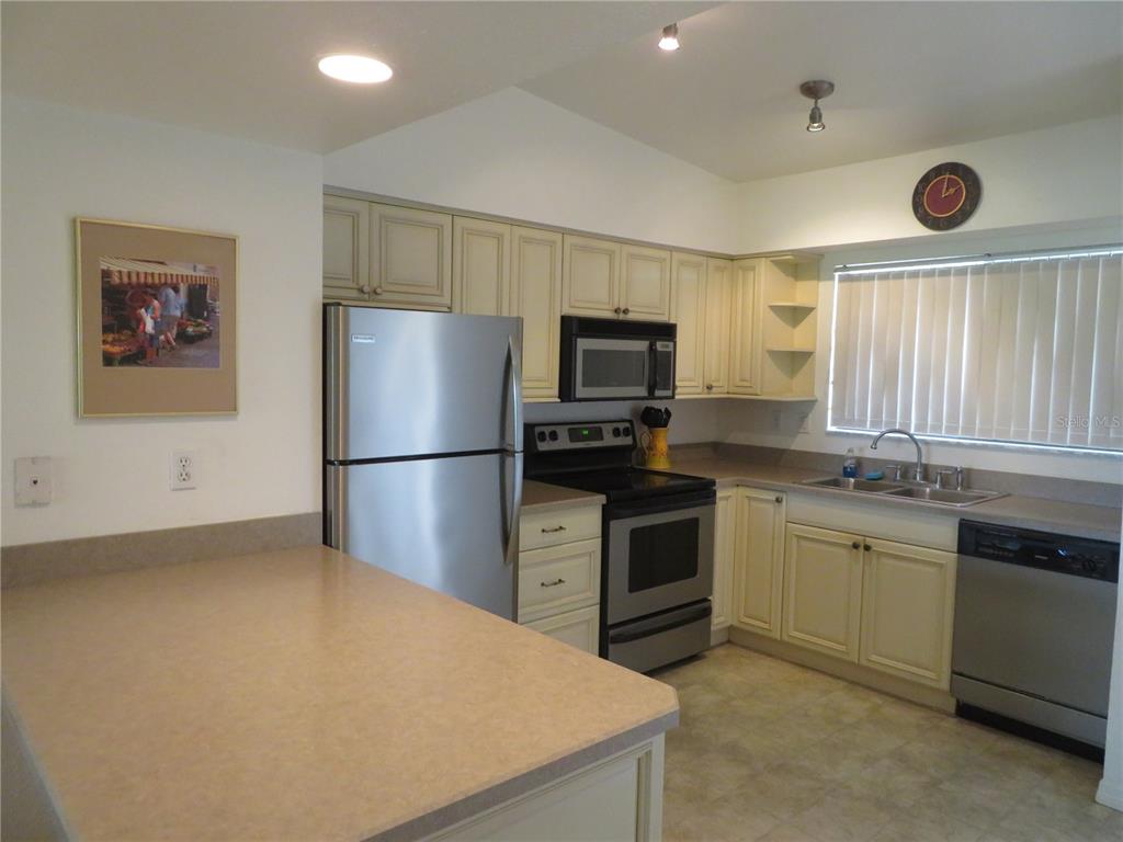 1360 Rio De Janeiro Avenue, Unit 117 Punta Gorda, FL 33983 - Photo 12 of 20 a kitchen with stainless steel appliances granite countertop a refrigerator stove top oven a sink and dishwasher