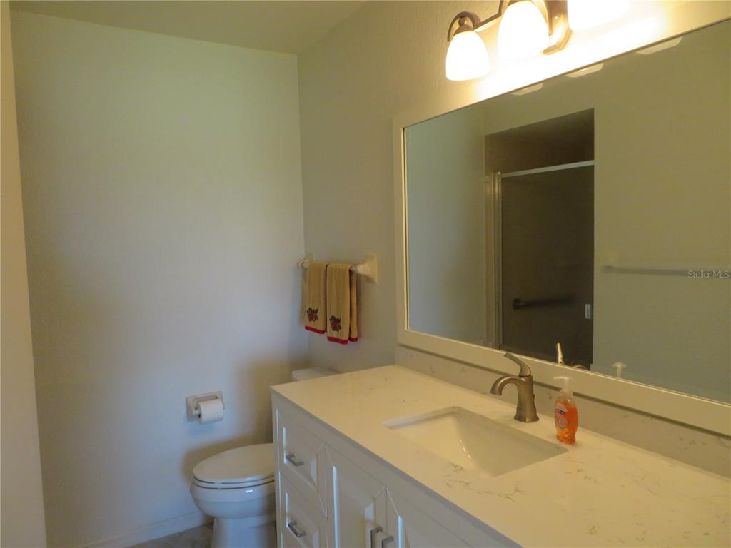 1360 Rio De Janeiro Avenue, Unit 117 Punta Gorda, FL 33983 - Photo 17 of 20 a bathroom with a granite countertop sink and a mirror