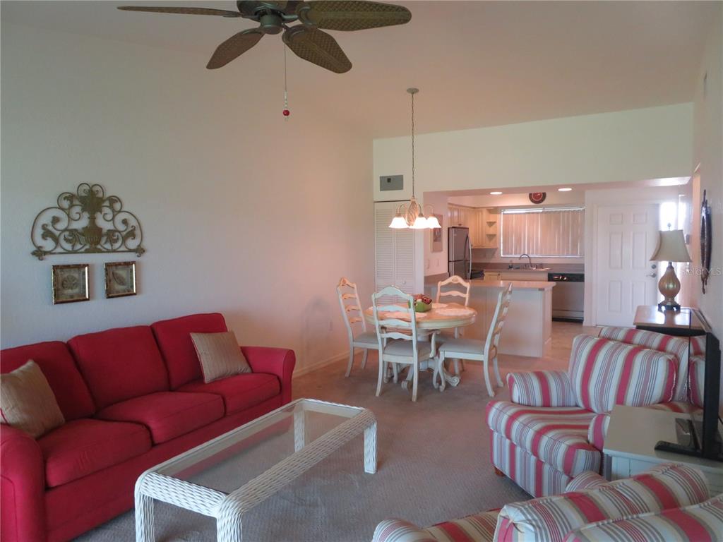 1360 Rio De Janeiro Avenue, Unit 117 Punta Gorda, FL 33983 - Photo 6 of 20 a living room with furniture kitchen view and a chandelier