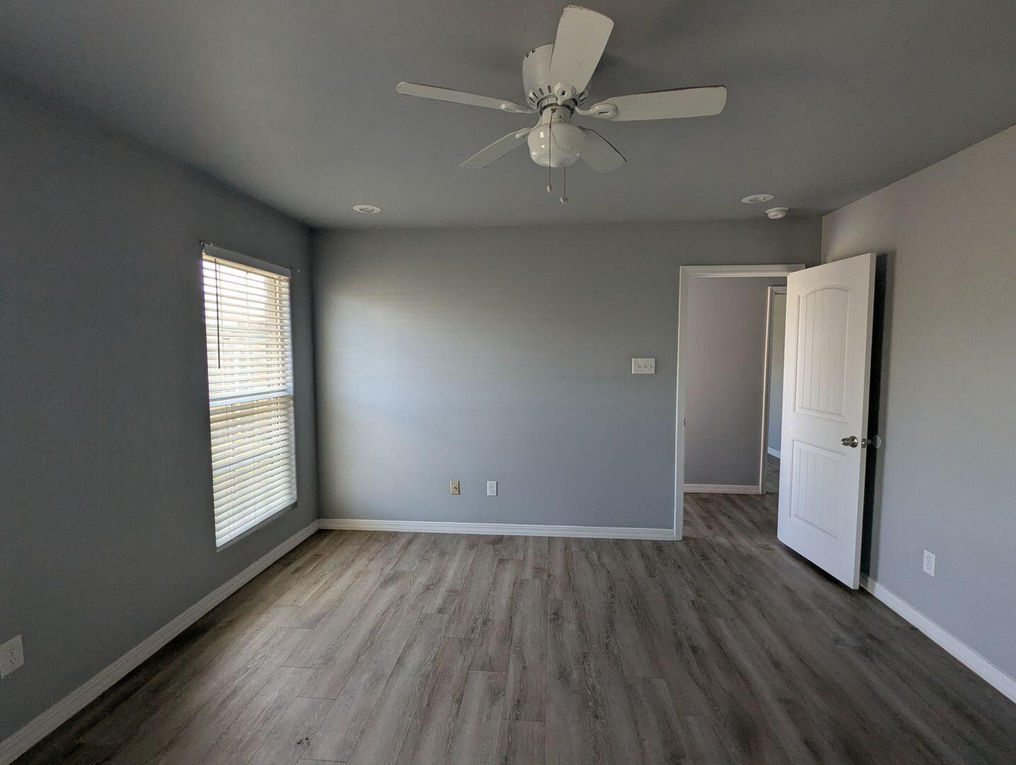 1302 North Clinton Avenue, Unit A & B Lubbock, TX 79416 - Photo 12 of 17 an empty room with wooden floor ceiling fan and windows