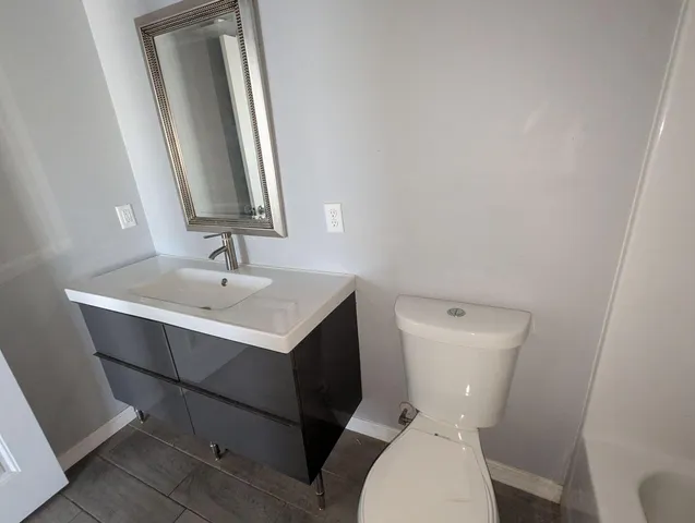 a white toilet sitting next to a bathroom sink
