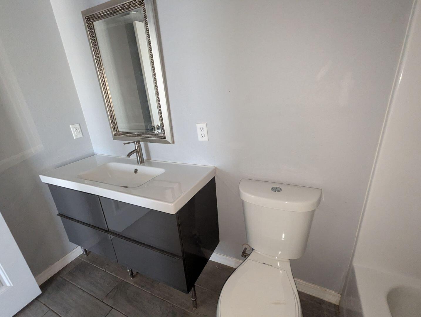 1302 North Clinton Avenue, Unit A & B Lubbock, TX 79416 - Photo 15 of 17 a white toilet sitting next to a bathroom sink