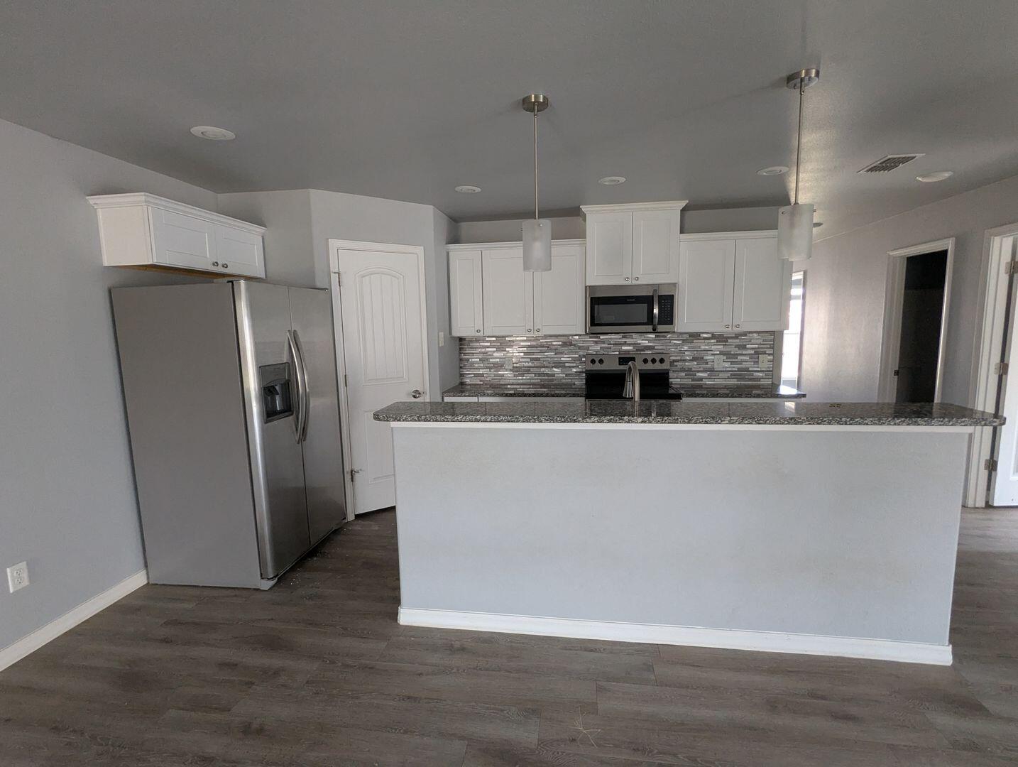 1302 North Clinton Avenue, Unit A & B Lubbock, TX 79416 - Photo 3 of 17 a kitchen with stainless steel appliances granite countertop a refrigerator a stove a sink and a microwave