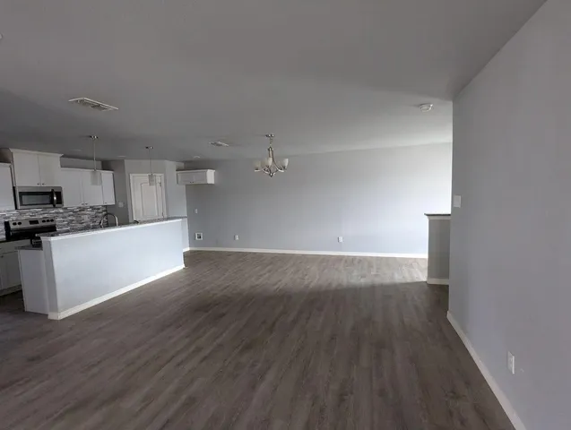 a view of a kitchen with wooden floor and electronic appliances