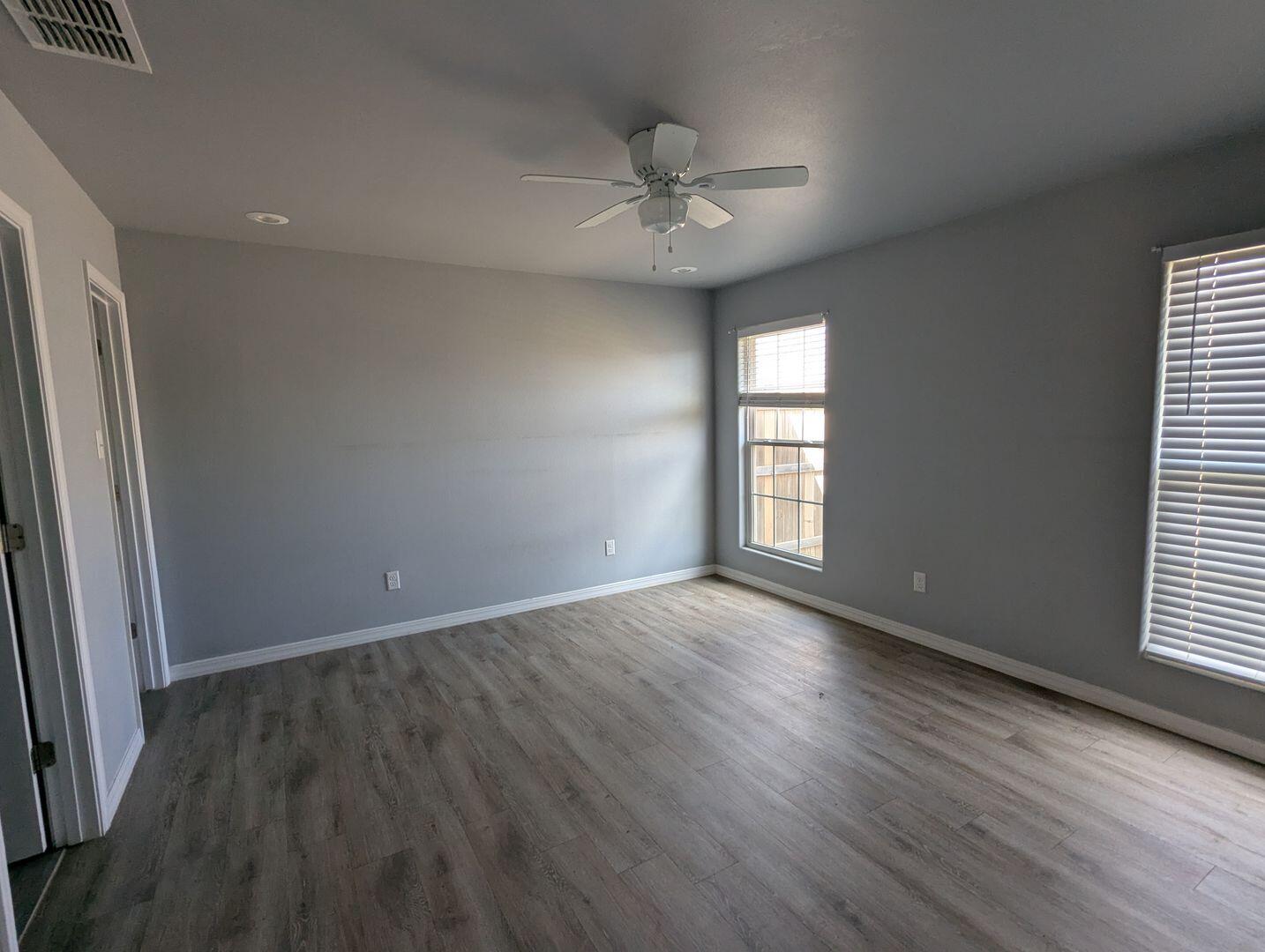 1302 North Clinton Avenue, Unit A & B Lubbock, TX 79416 - Photo 9 of 17 an empty room with wooden floor and windows