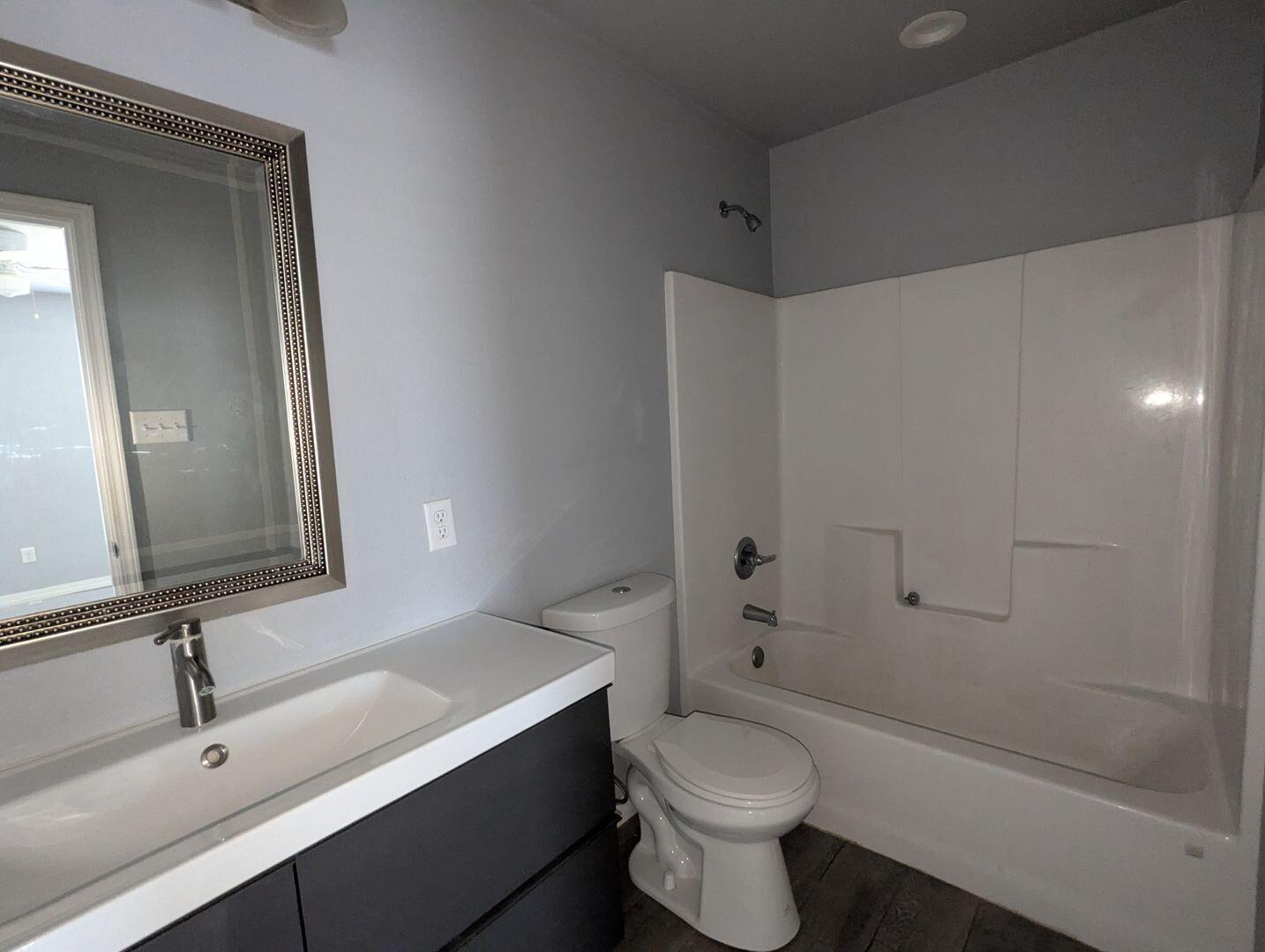 1302 North Clinton Avenue, Unit A & B Lubbock, TX 79416 - Photo 10 of 17 a bathroom with a sink a toilet and shower