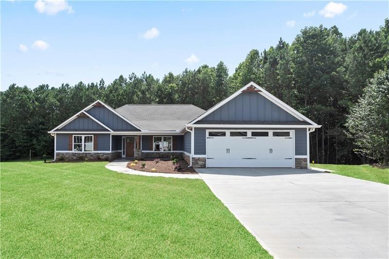 a front view of a house with a yard and trees
