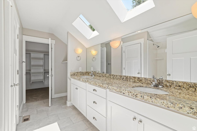 847 225 South Springville, UT 84663 - Photo 13 of 23 Master bath. Double vanity with granite countertop and integrated sinks, white cabinetry, tile flooring, two skylights, and sconce lighting