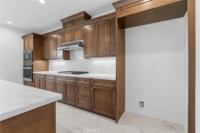 a kitchen with stainless steel appliances granite countertop a sink and a stove