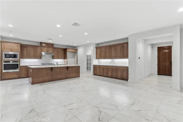 a large white room with a large window and kitchen view