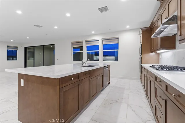 a kitchen with stainless steel appliances granite countertop a sink and a stove