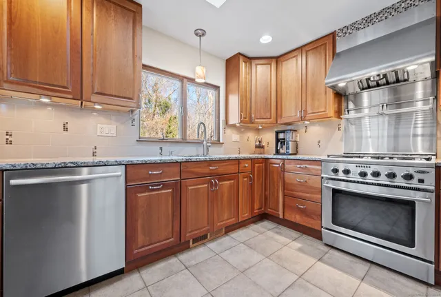 a kitchen with stainless steel appliances granite countertop a stove sink and cabinets
