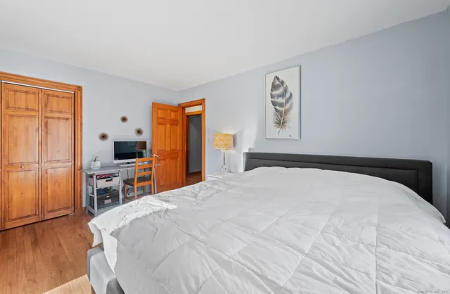 a bedroom with a large bed and a flat tv screen