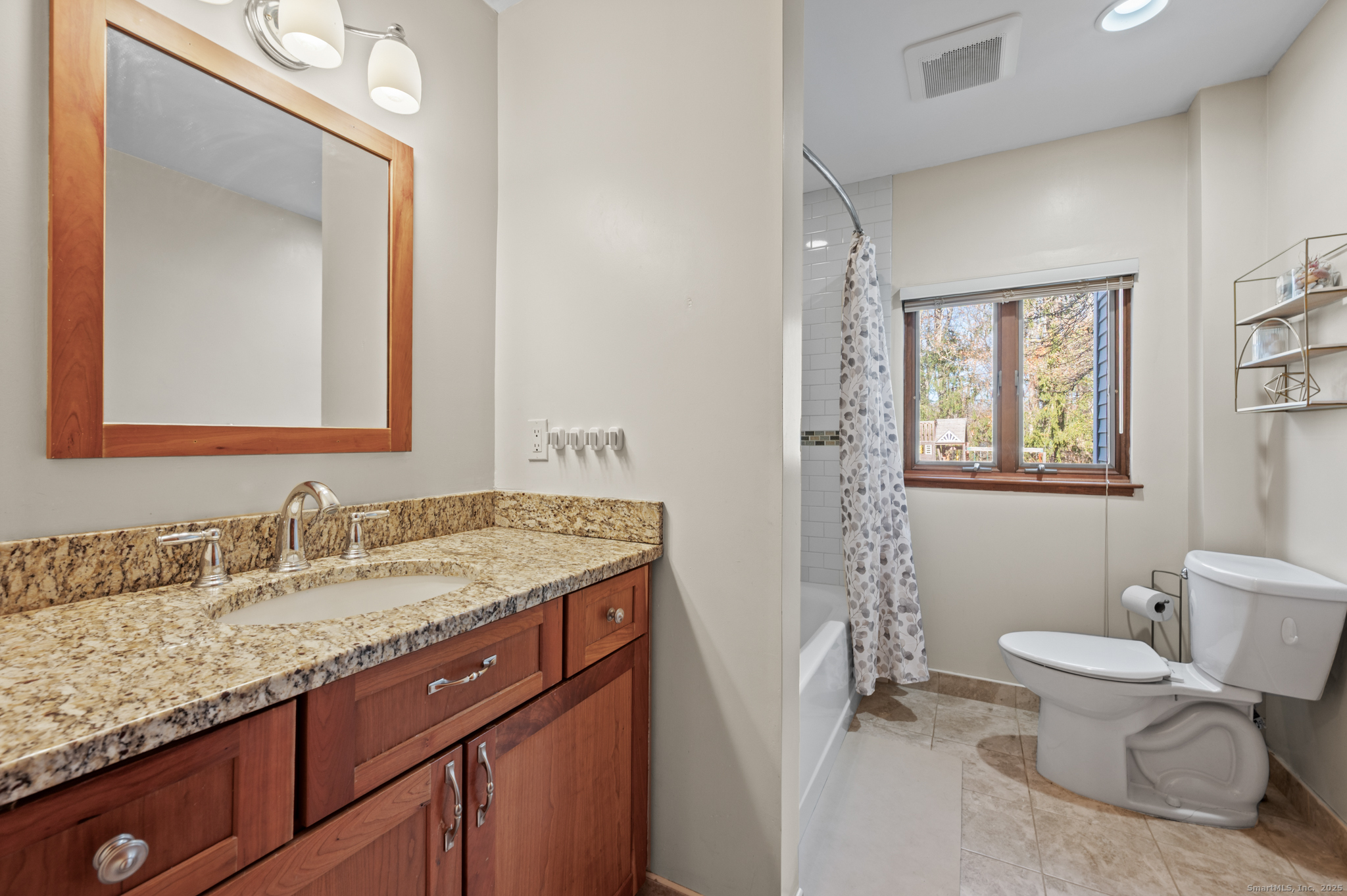 26 Farm View Drive Madison, CT 06443 - Photo 16 of 37 a bathroom with a granite countertop toilet a sink and a mirror