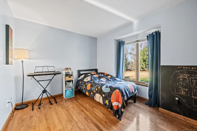 a bed sitting in a bedroom next to a window