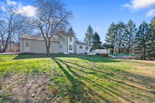 a view of a house with a big yard and large tree