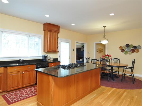 15 Hastings Road Weston, MA 02493 - Photo 7 of 21 a kitchen with granite countertop a stove a sink a dining table and chairs