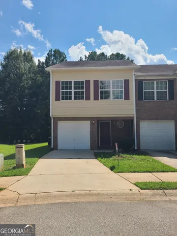 a front view of a house with a garden and yard