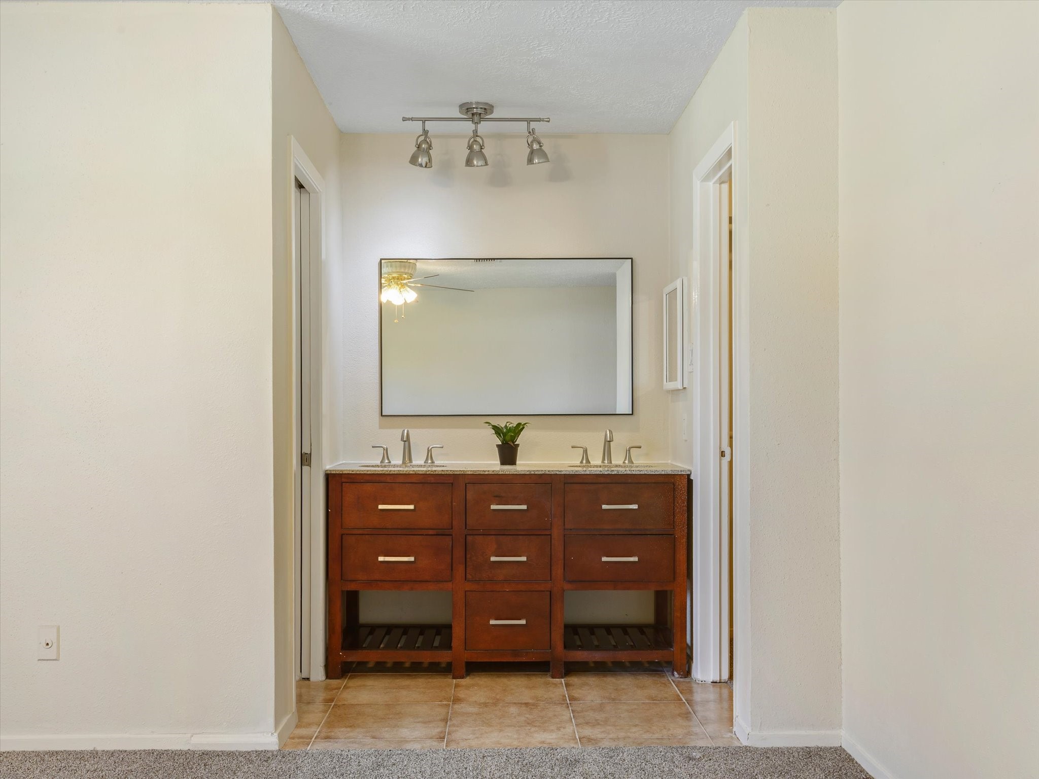 2507 Kings Chapel Road Friendswood, TX 77546 - Photo 12 of 28 The vanity portion of the master bathroom is open to the bedroom and it features a dresser style vanity with dual rectangular basin sinks, granite countertops, modern hardware, a framed mirror, and a separate wet room for the shower and commode.