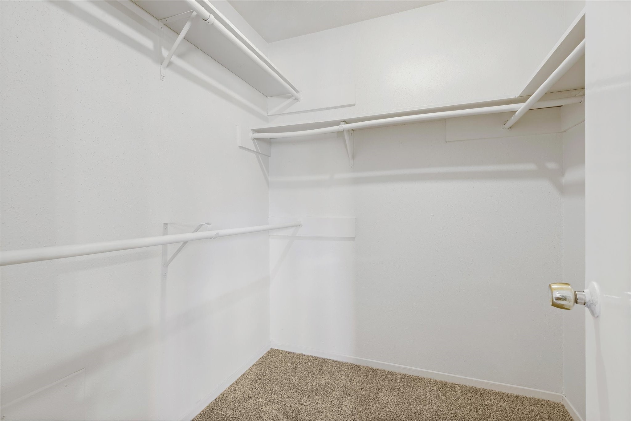 2507 Kings Chapel Road Friendswood, TX 77546 - Photo 14 of 28 The primary suite offers a spacious walk-in closet with multiple hanging levels and built-in shelving for easy organization. Neutral finishes and ample storage space make it functional and easy to customize to your needs.