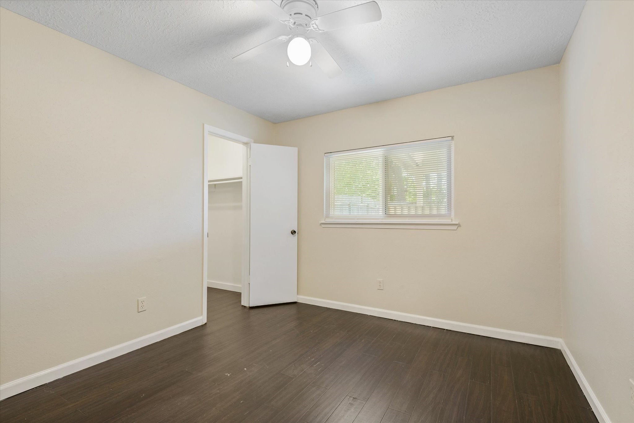 2507 Kings Chapel Road Friendswood, TX 77546 - Photo 15 of 28 This secondary bedroom features bamboo flooring, neutral paint, and a large window that fills the room with natural light. A walk-in closet adds functionality, making this a comfortable space for guests or family.