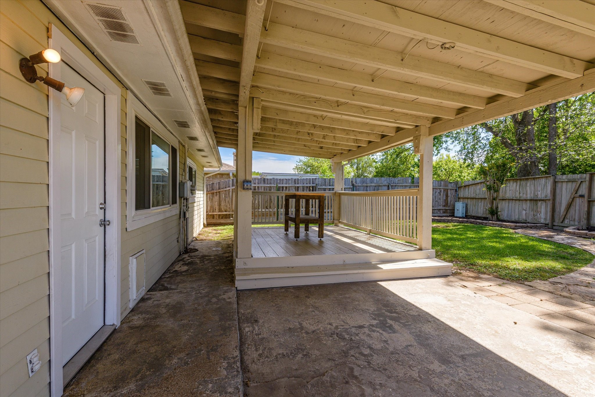 2507 Kings Chapel Road Friendswood, TX 77546 - Photo 18 of 28 Step out back to a covered patio that offers a shaded space for relaxing or dining, with plenty of room for seating. The extended concrete area adds additional flexibility, while the overhead cover provides protection from the Texas sun.