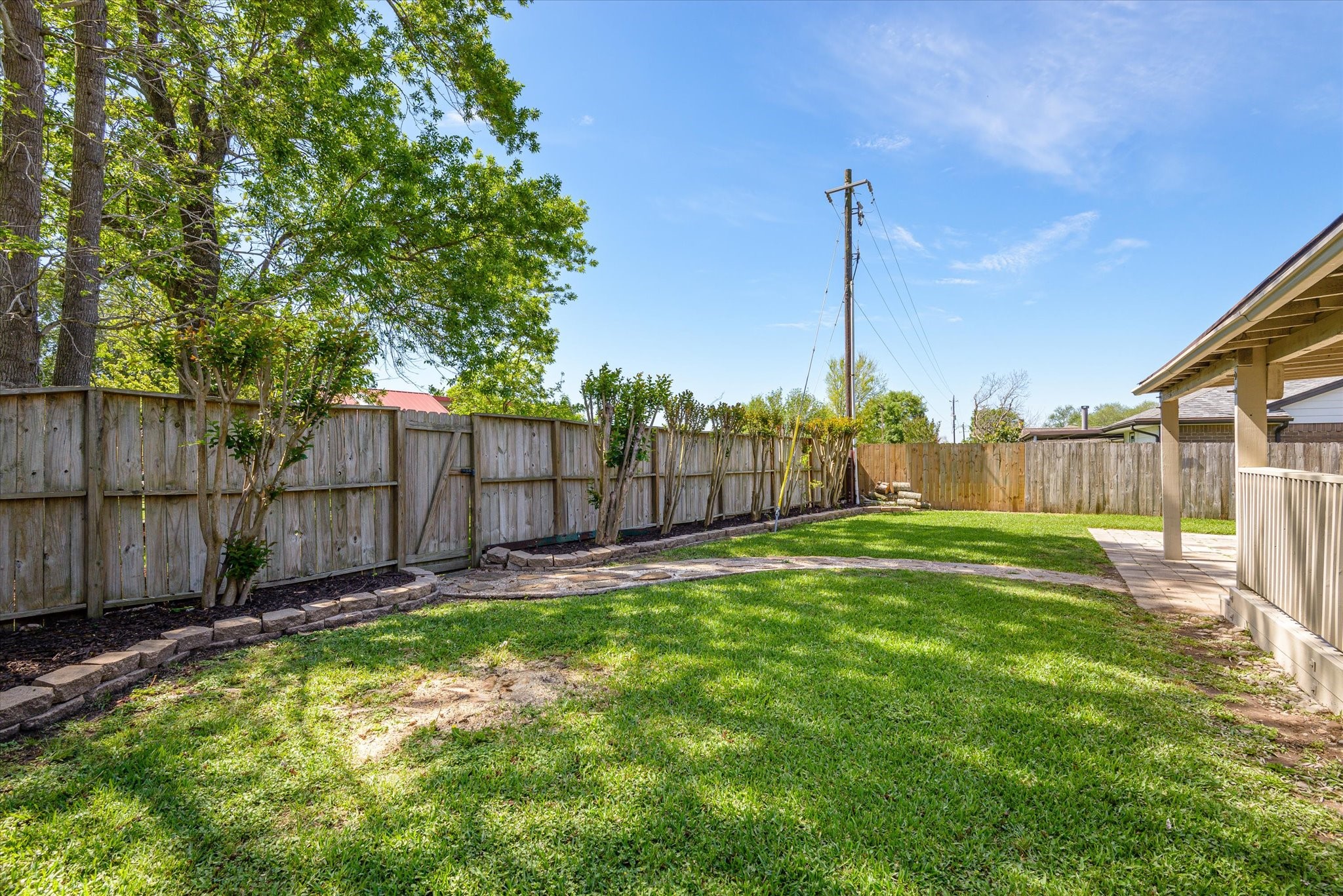 2507 Kings Chapel Road Friendswood, TX 77546 - Photo 24 of 28 A closer look at the backyard shows a landscaped border along the fence line and a curved stone walkway that adds leading to to the back gate that opens directly to the neighborhood park & pool. There is plenty of room here to customize with gardens, play areas, or additional seating.