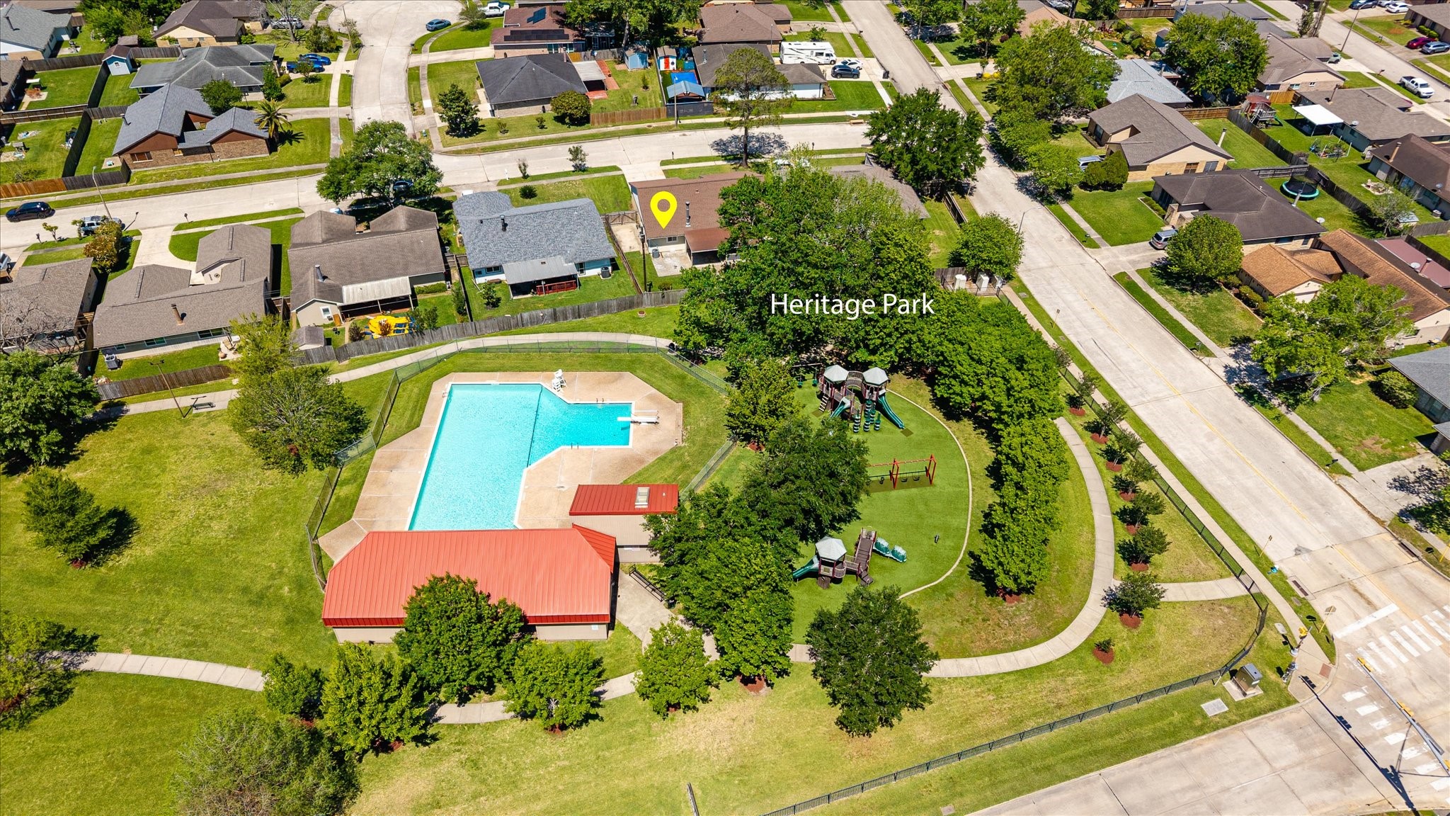 2507 Kings Chapel Road Friendswood, TX 77546 - Photo 25 of 28 An aerial view showcases the nearby community pool, playground, and green space just beyond the backyard. This close proximity makes it easy to enjoy neighborhood amenities without the maintenance.